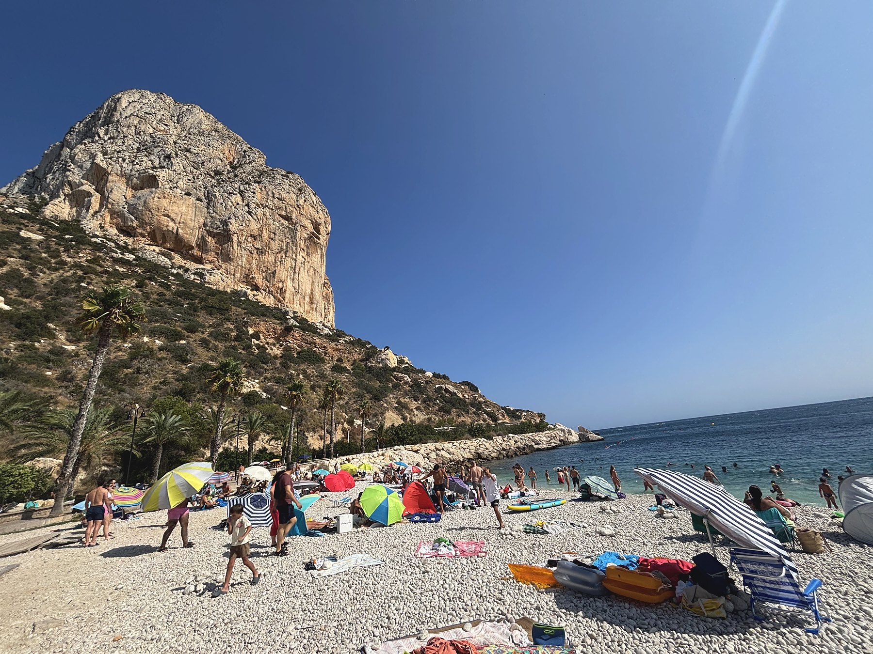 Zátoka s okrúhliakmi Cala del Racó pod kolmou stenou Peñónu de Ifach v Calpe