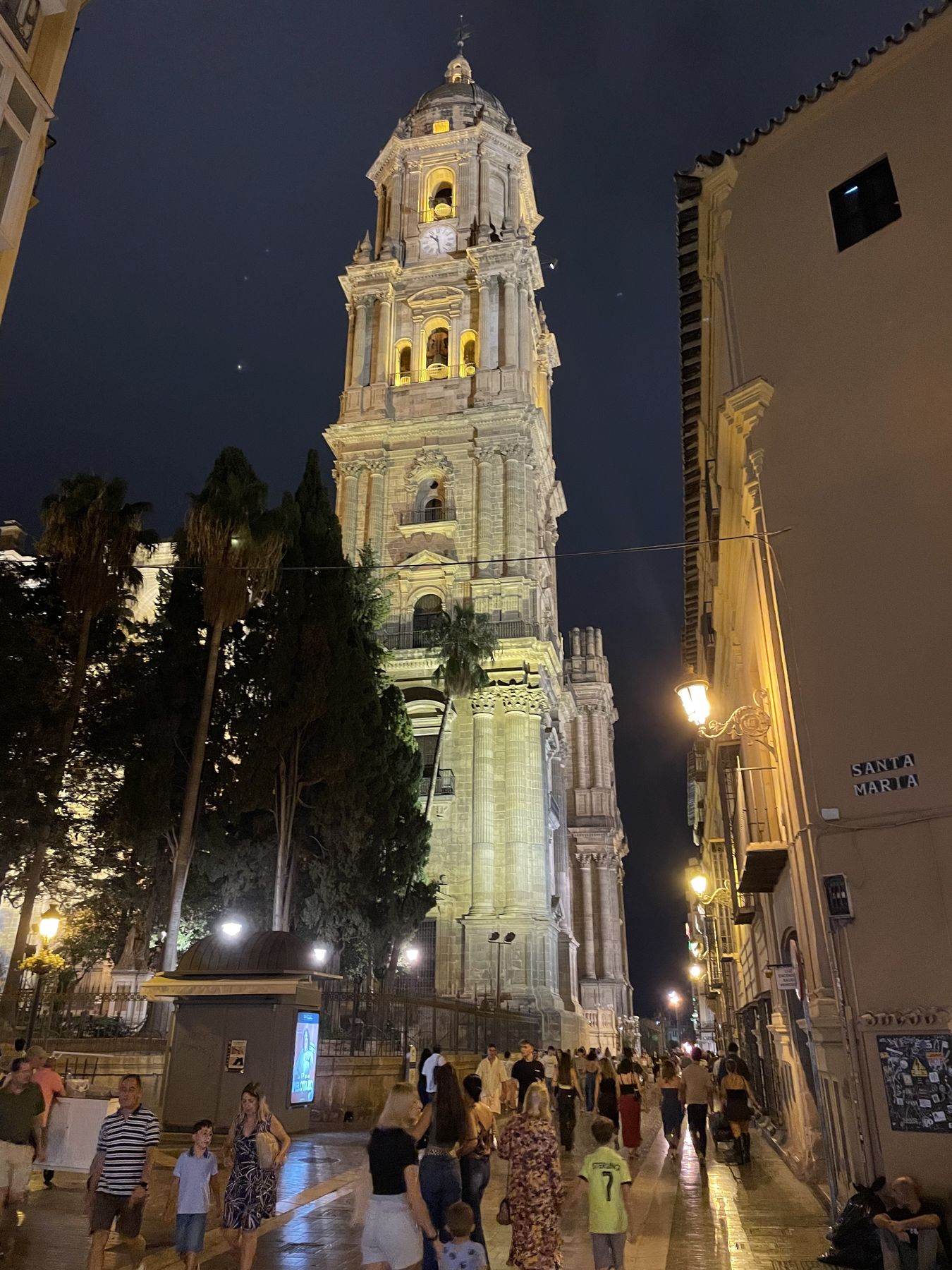 Večerná ulica Santa María v Málage s ľuďmi, v pozadí veža katedrály
